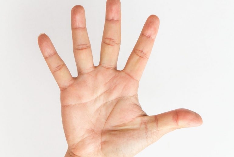 Male hand stretching out on white