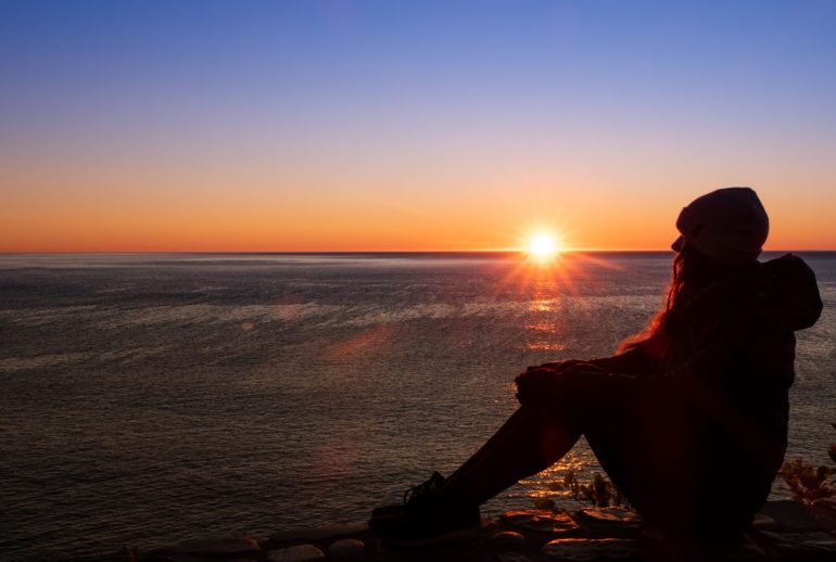 Silhouette,Of,A,Young,Woman,Admiring,The,Sunrise,At,Cap